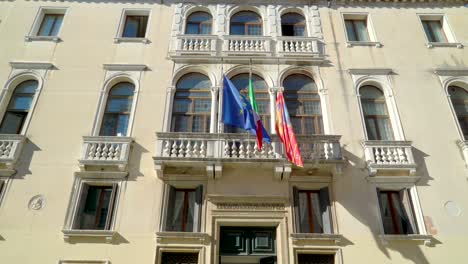 tres banderas en la veranda de la ventana del palacio en venecia, italia