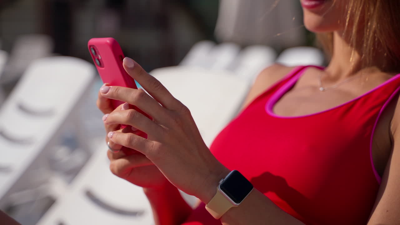 Woman relaxing by the pool, using her phone