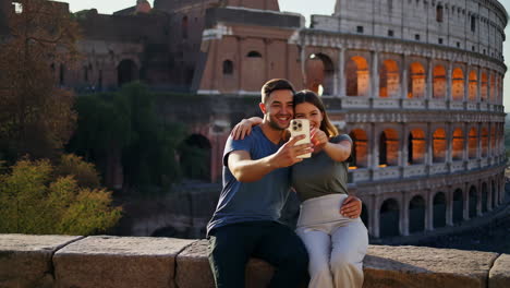 couple taking selfie in front of the colosseum