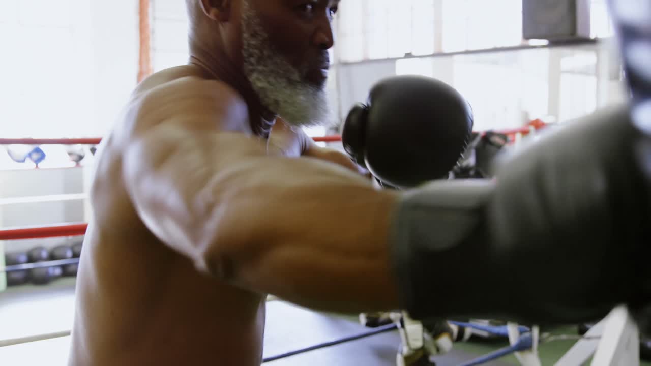 Homem idoso praticando boxe no saco de pancadas 4k