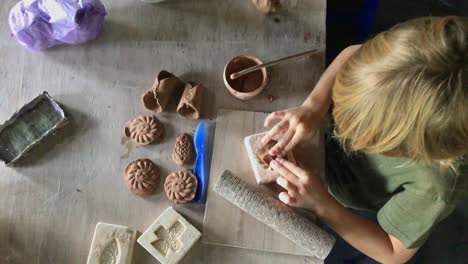 a little boy in a pottery class. shot on a phone