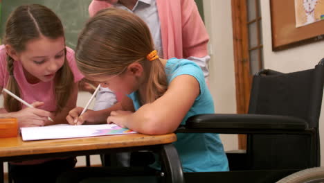 Teacher-watching-children-drawing-during-lesson