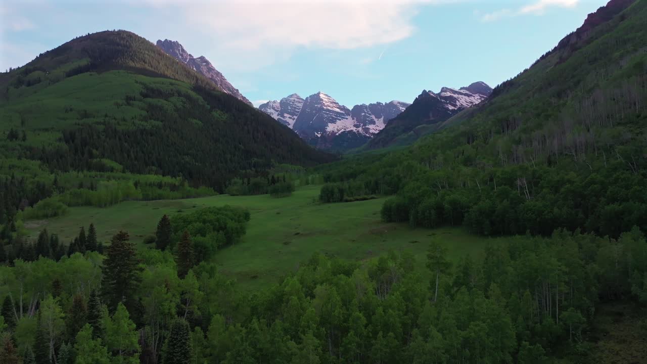 Maroon Bells Wilderness valley Elk Range Rocky Mountains Colorado aerial drone North Maroon Pyramid Peak 14er sunset spring summer blue sky clouds Aspen Snowmass White River Forest forward pan up