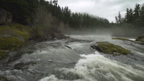 camera pans across south umpqua river and foggy forest