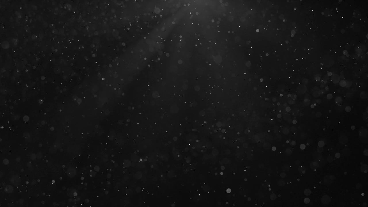 黒背景に光線で照らされた浮遊するホコリの粒子