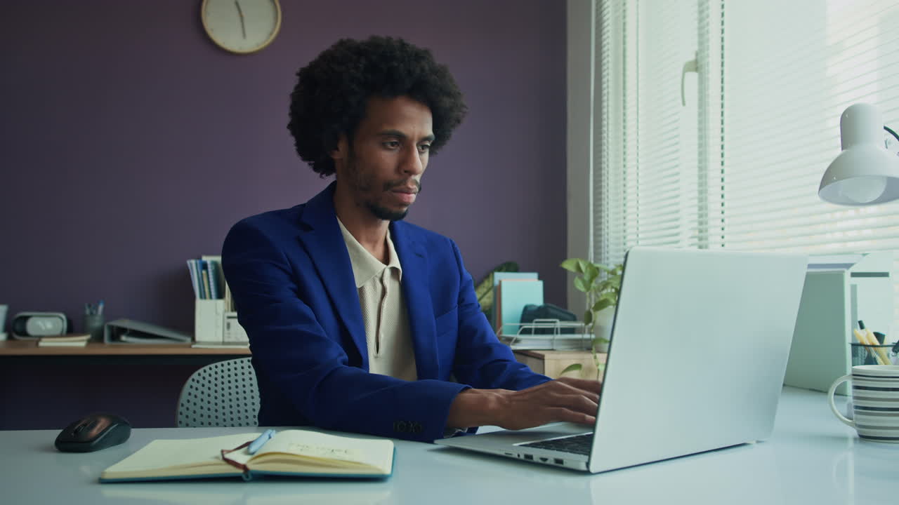 Black Businessman Working on Laptop at Modern Office
