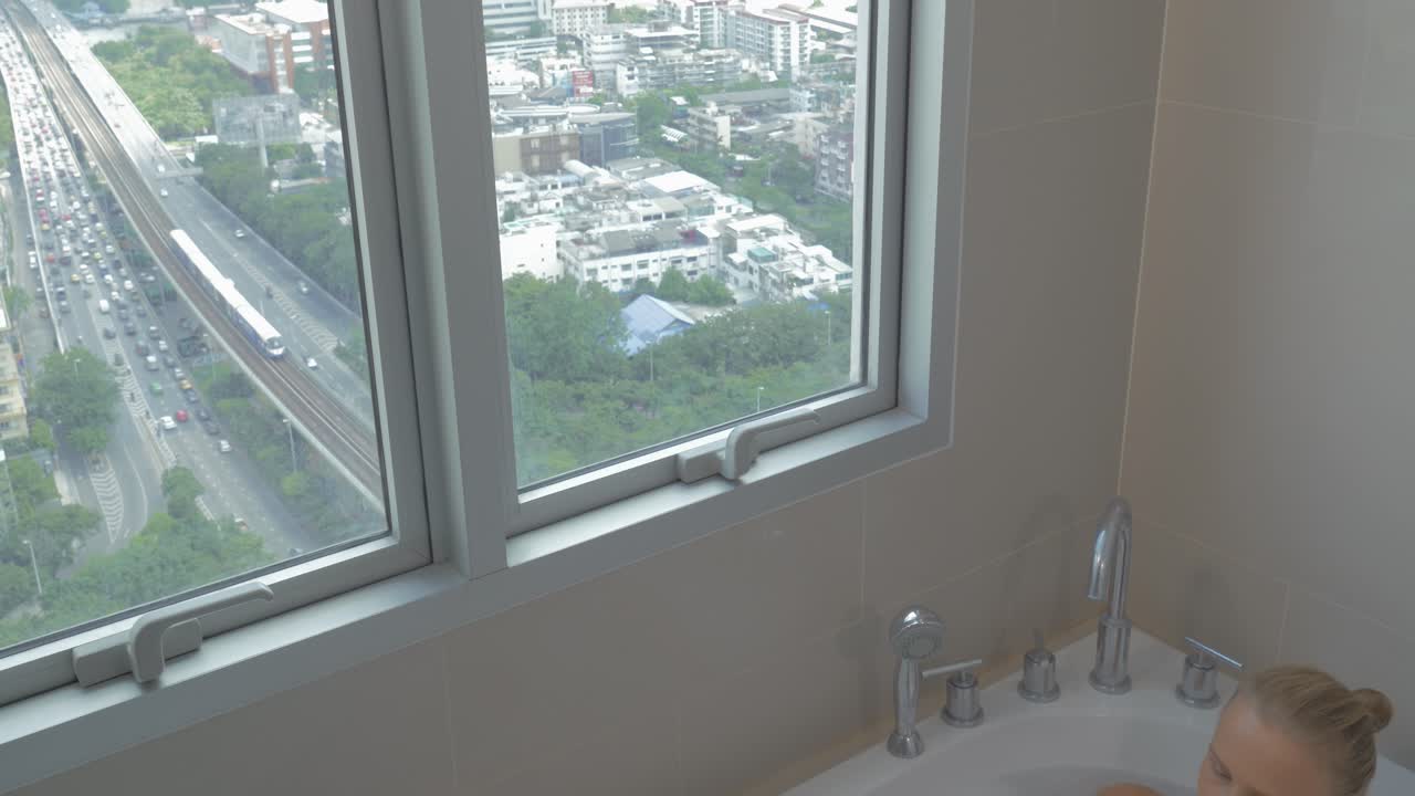 mujer con almohadilla táctil relajándose en el baño