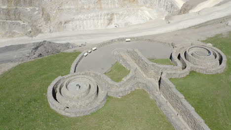 una vista aérea de primer plano de las obras de arte públicas cortadas con piedras frías cerca del puente de pateley con una cantera de asfalto en el fondo