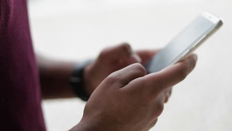 close up shot of mixed-race male hands texting on phone