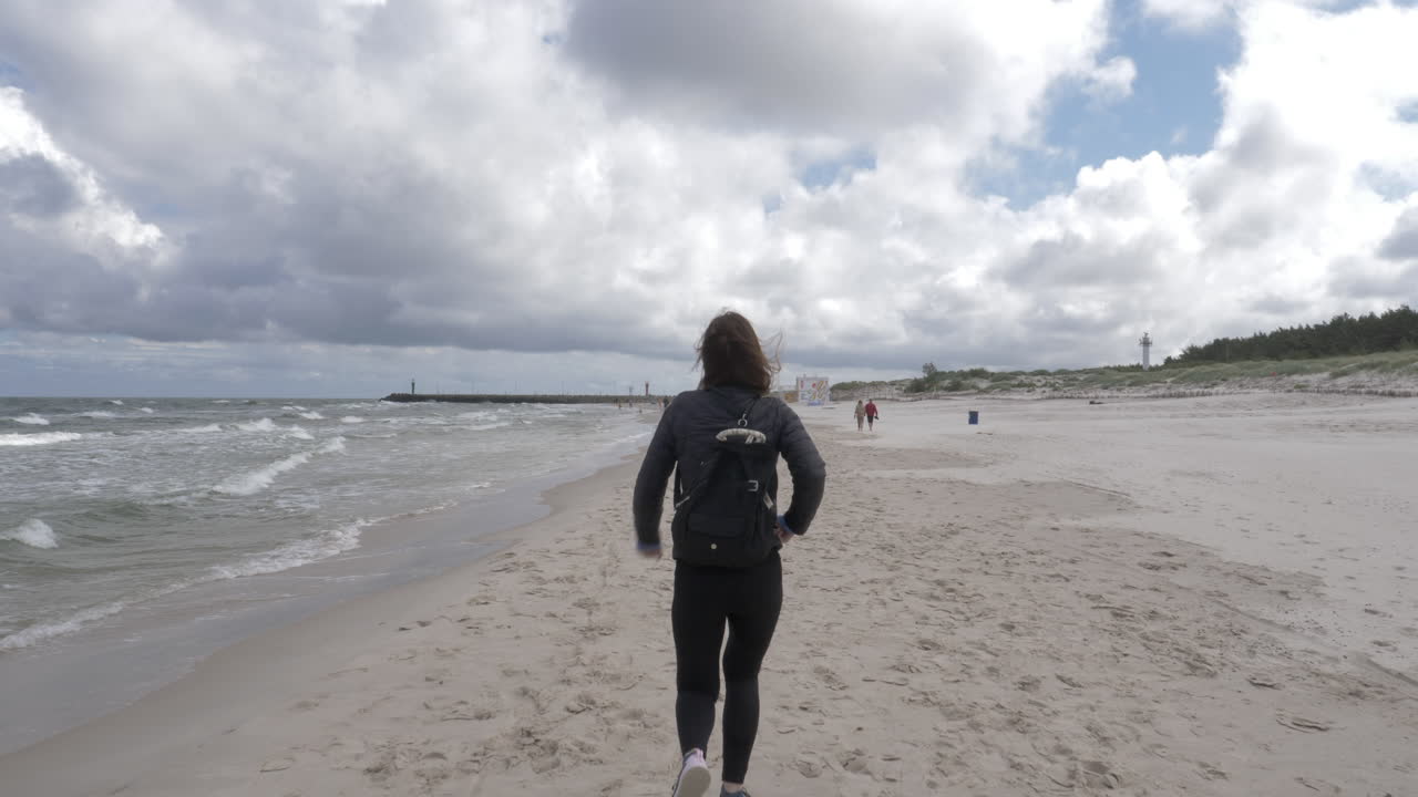 여자는 해변에서 기쁨을 위해 점프