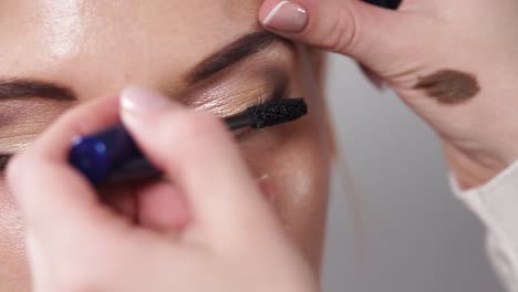 applying mascara and eyeshadow