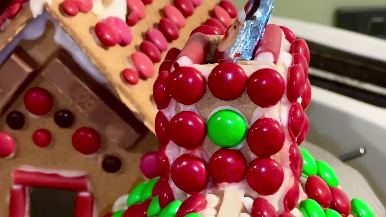 크리스마스 때 장식된 진저브레드 하우스 굴의 극심한 클로즈업 빨간색과 녹색 사탕.