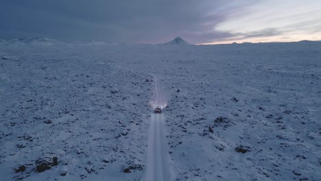 driving through snowy mysterious volcanic land towards mountain, iceland