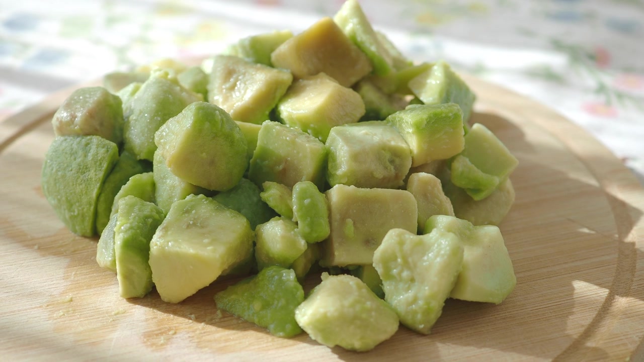 Primo piano di avocado fresco a cubetti su un tagliere di legno