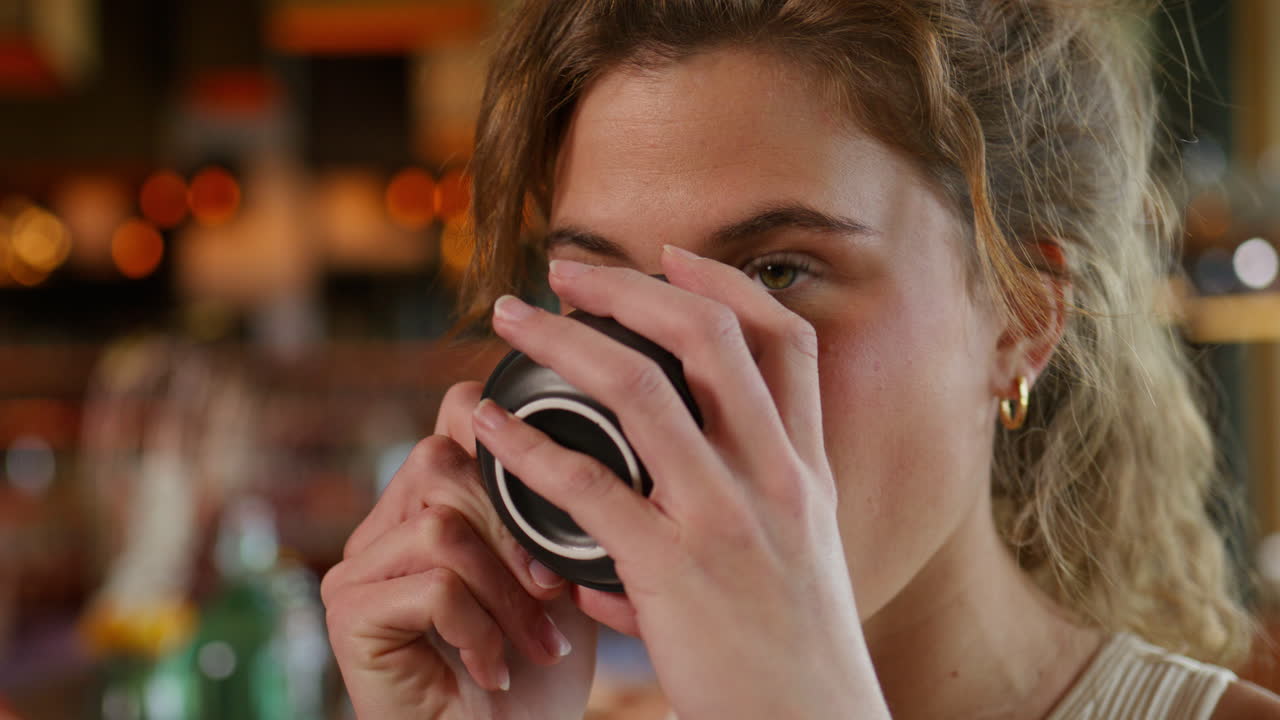Donna in abbigliamento sportivo che si gode un caffè in un lussuoso ambiente alpino nelle Alpi svizzere. Momento di relax pre-allenamento, atmosfera calma e stile di vita premium con viste panoramiche sulle montagne.