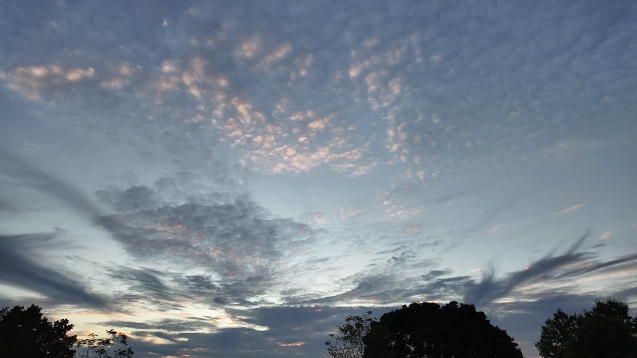 White cumulus clouds drift by in a gray sky.