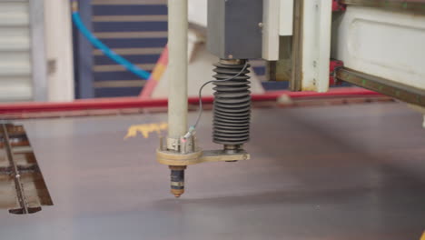 close up of cnc plasma cutter head aligning on steel metal sheet in workshop, 4k