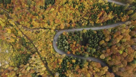 Aerial-flies-above-Car-driving-over-a-Mountain-Pass-during-autumn-at-Gempen,-Baselland,-Switzerland