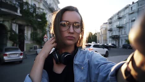 Portrait-Of-An-Attractive-Girl-With-Outstreched-Hand-Posing-For-Camera,-Corrects-Her-Short-Hair