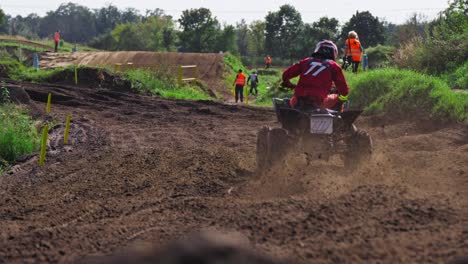 slow motion quad bike coming onto a curb on dirt