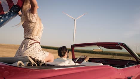 Video-of-happy-woman-in-a-car-with-American-flag