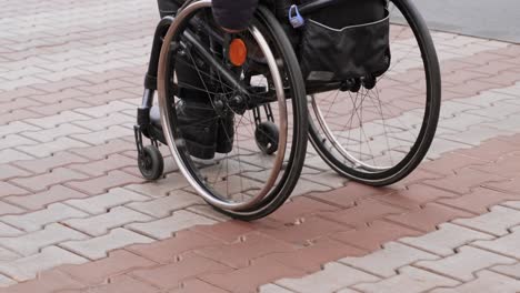 a person with a disability moves along the street in a wheelchair