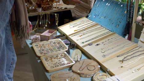 a customer is looking at rings and bracelets at an antique booth