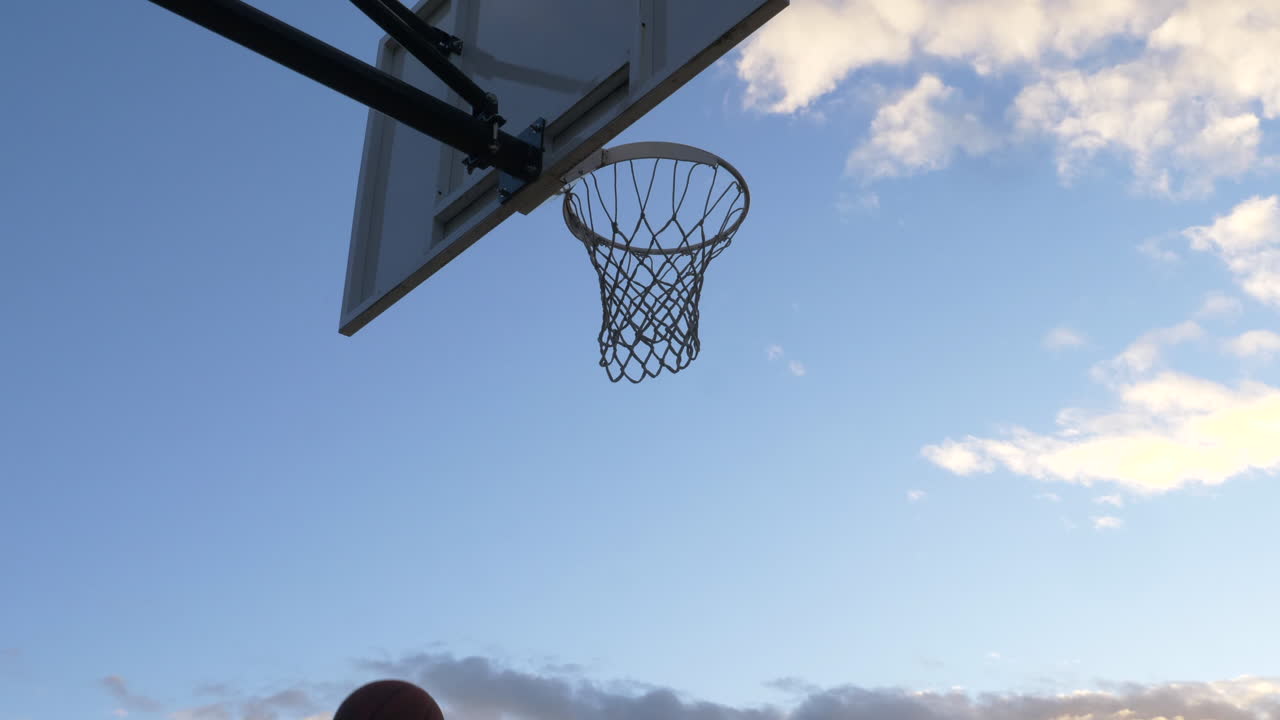 캐나다 밴쿠버의 농구 코트에서 레이업 샷을 하고 있는 농구 선수 - 낮은 앵글 샷