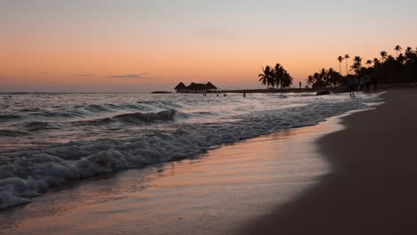 ondas do mar rolando na praia tropical ao pôr do sol