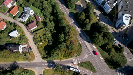aerial top down shot of driving bus on road and polish neighborhood during sunny day in gdynia city