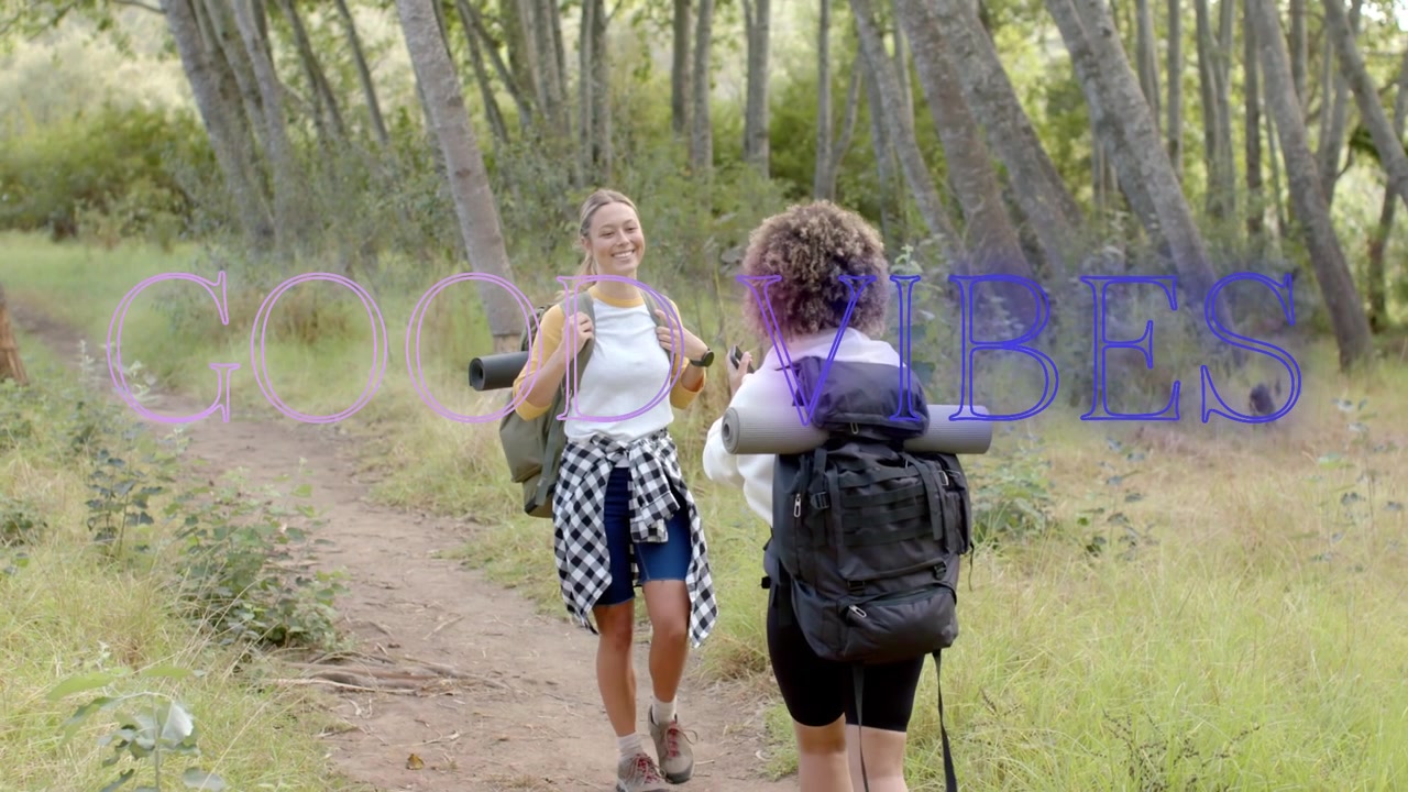Escursionista che alza il telefono mentre un amico si avvicina, scattando un selfie di trekking e abbracciandosi, con la scritta GOOD VIBES che appare.