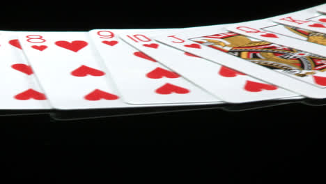 a deck of cards laid out rotates in front of a camera