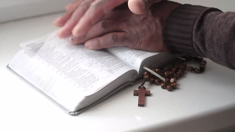 praying to god with hands together with bible and cross black man praying with black background stock video stock footage