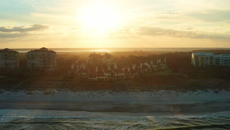 aerial, luxurious beachside vacation villas on an island during sunset
