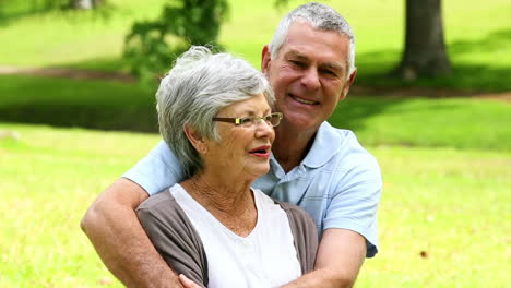 Affectionate-senior-couple-relaxing-in-the-park-