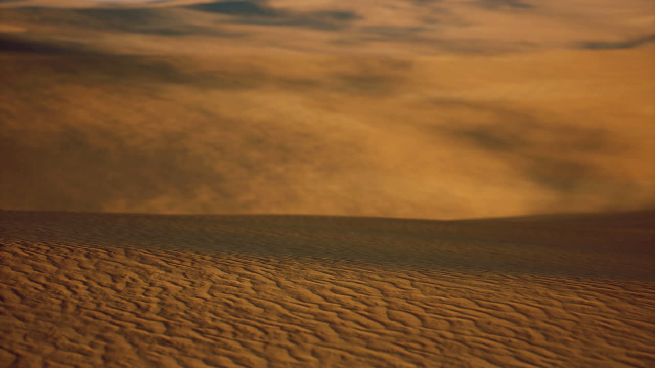 Golden desert sands shift under the warm afternoon sun in a quiet landscape