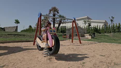 young female child all alone having fun in a playground, panning shot