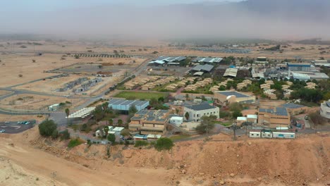 High-aerial-view-of-Kibbutz-Yotvata,-southern-Arava,-Israel-showing-modern-infrastructure-and-a-Negev-desert-sandstorm