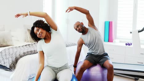 couple exercising together on exercise ball 4k