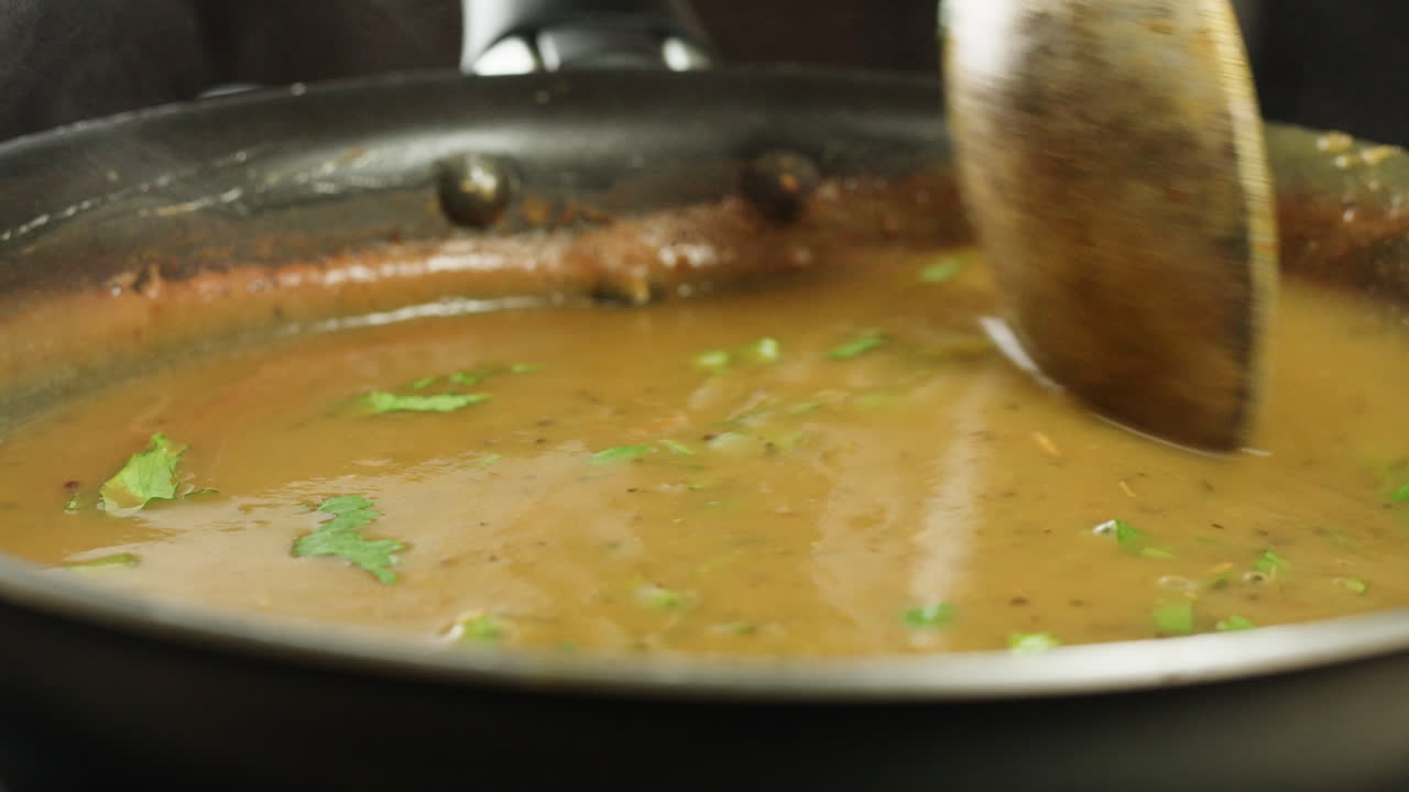 Cooking traditional Indian meal Palak Panir with spinach and cheese close up. Palak paneer is an Indian dish, consisting of paneer in a thick paste made from pureed spinach, Palak paneer is prepared by first boiling and pureeing spinach.