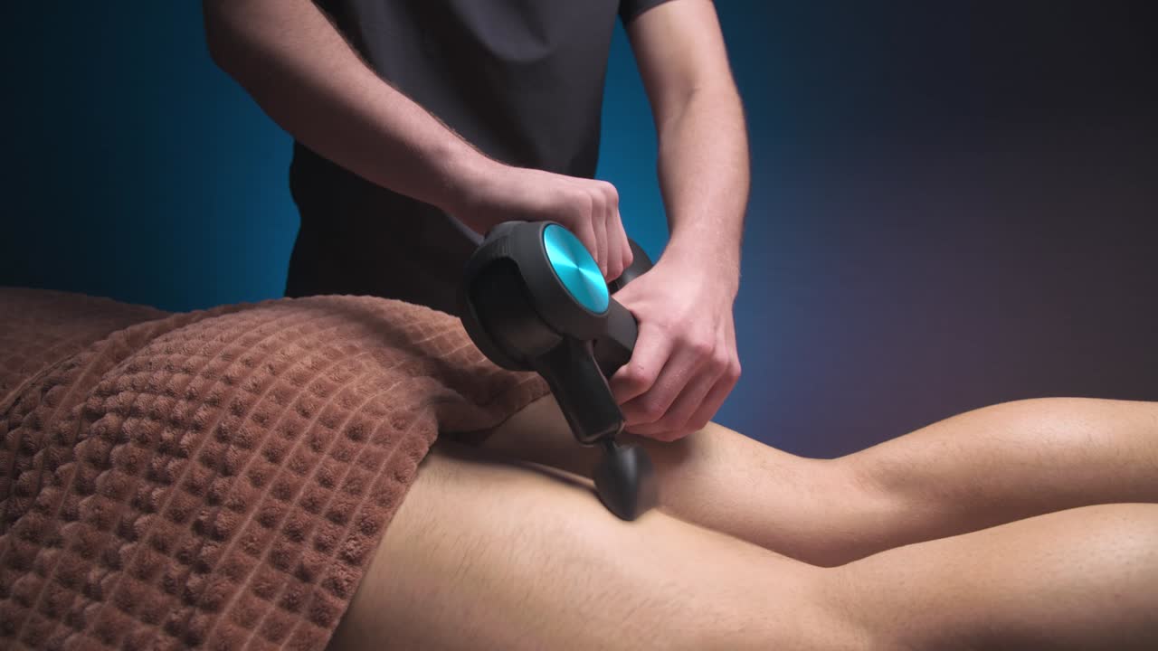 Percussion massage on the back of the leg. Massage the back of the thigh and the back of the calf muscles. Working as a percussion massager