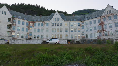 low aerial of tourists and van in front of mysterious lyster sanatorium, sogn