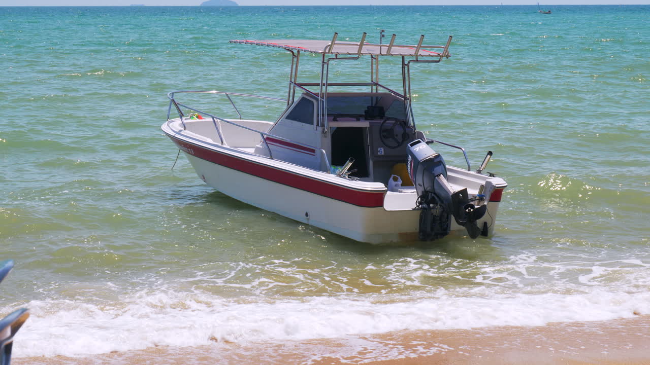 una lancha rápida anclada con seguridad en una hermosa orilla en un día soleado y brillante donde la marea es alta pero el mar está tranquilo y las olas pasan suavemente