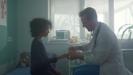 pediatrician using oximeter checking oxygen saturation on girl finger close up.