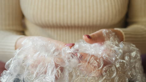 A-woman-pops-bubble-wrap