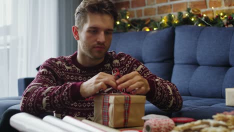 young adult man packing christmas gifts.