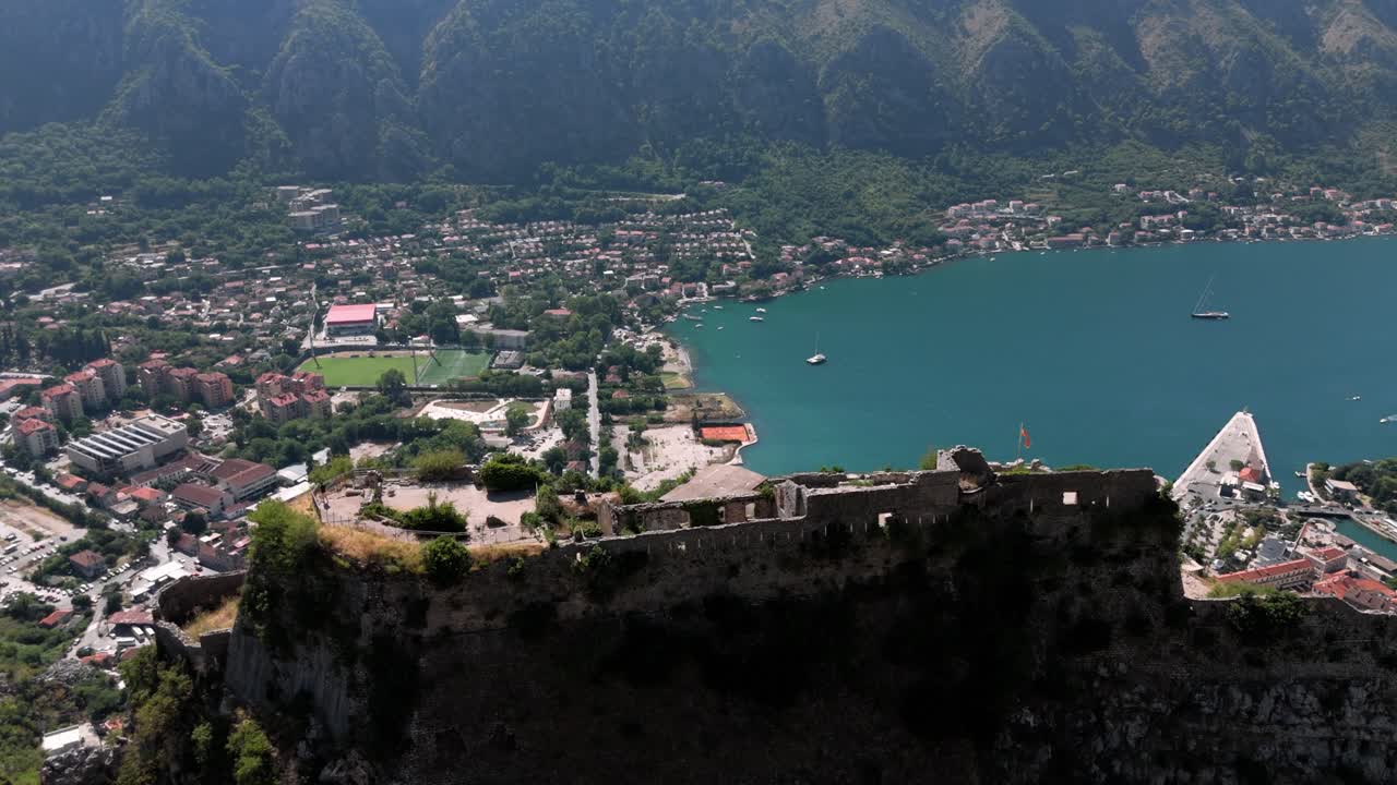 Flying closely over the Fortress of Koton on the Mountain revealing high view on the adriatic sea, Port and city landscape in Montenegro