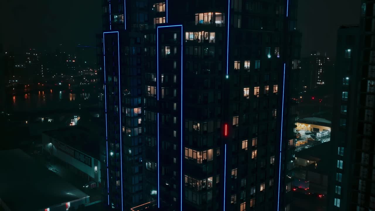 disparo lento acercándose a un edificio de gran altura, apartamentos de lujo, noche