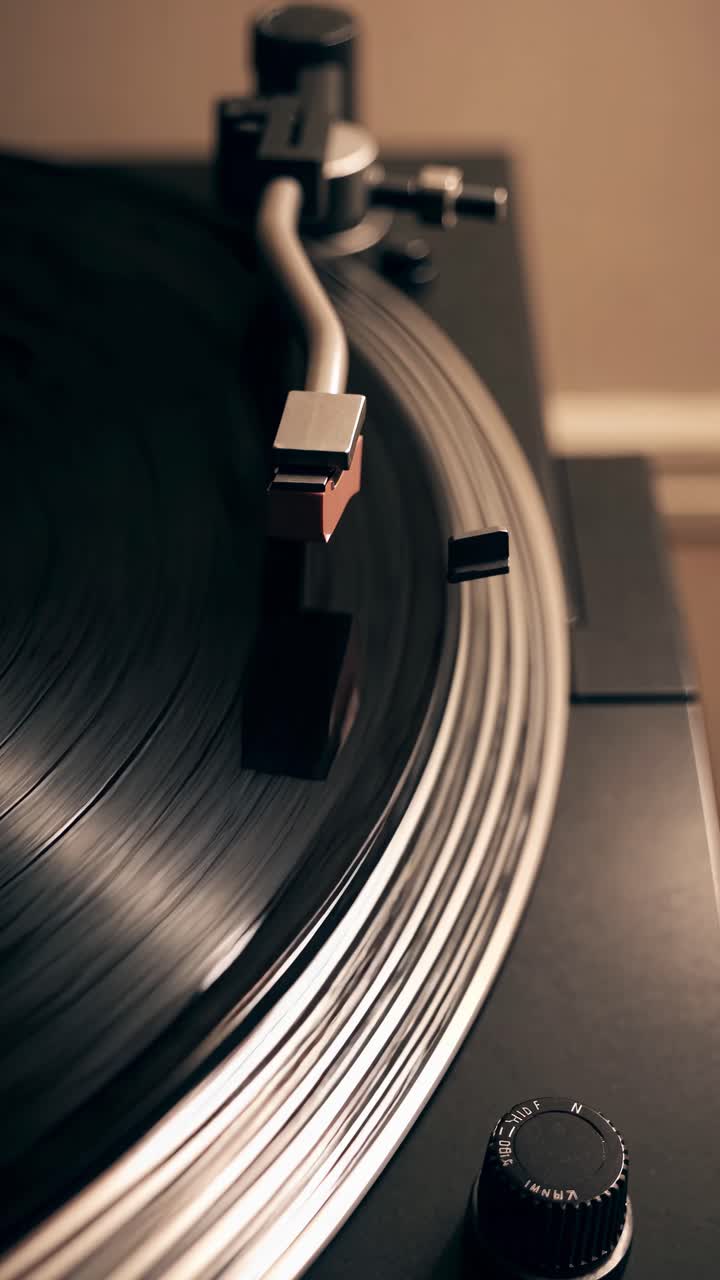 Close-up, angled shot of a vintage turntable spinning a vinyl record, capturing the retro vibe