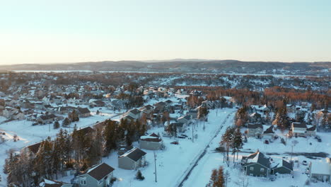 winter aerial over homes in a picturesque, snow covered community on a cold winter day